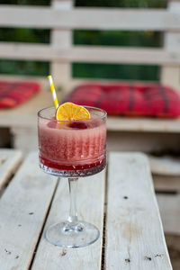 Close-up of red cocktaii in vintage glasss on white pallet table in bar