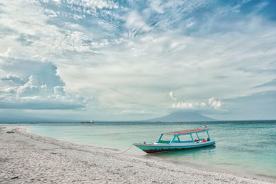 Boat moored on sea against sky