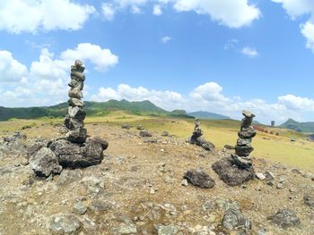 Stack of rocks on land against sky