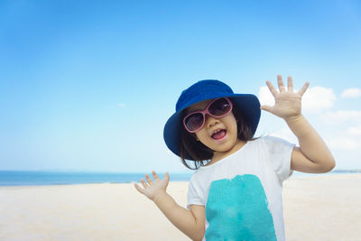 Portrait of boy standing on beach against clear blue sky