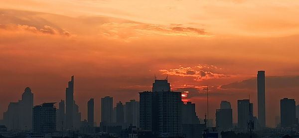 Modern buildings against sky during sunset