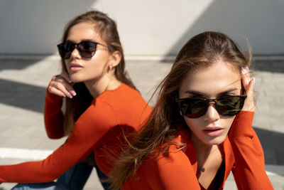 Portrait of young women with sunglasses sitting outdoors
