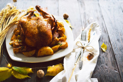 Autumn composition with leaves, ripe pumpkin and thanksgiving turkey on a dark wooden table.