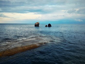 Scenic view of calm sea against cloudy sky