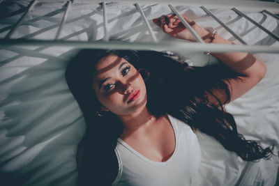 Portrait of a beautiful young woman lying on bed