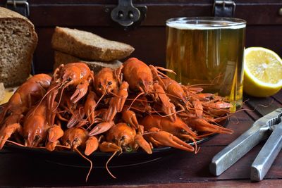 Close-up of lobsters with bread and drink on table