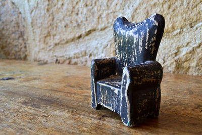 Close-up of old metal on table against wall