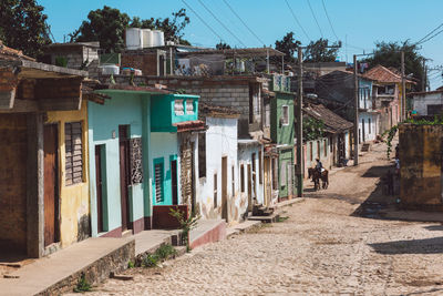 Street amidst houses against buildings in city