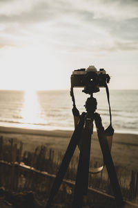 Full length of camera on beach against sky