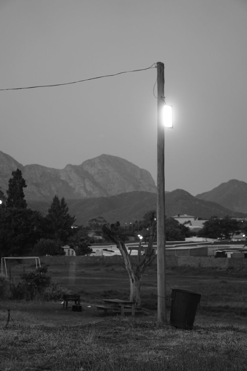 BUILT STRUCTURE ON FIELD AGAINST MOUNTAINS