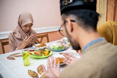 Family praying together during iftar at home