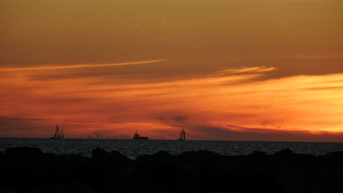 Boats in calm sea against scenic sky