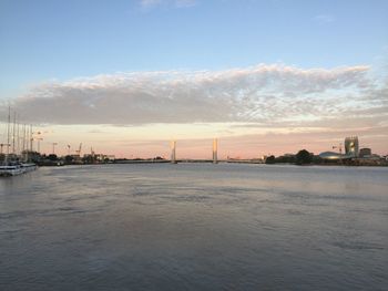 View of river and buildings against sky during sunset