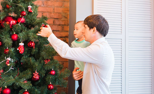 Rear view of man with christmas tree