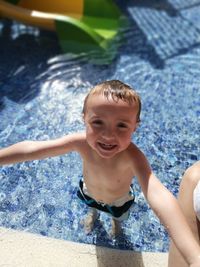 High angle portrait of smiling boy in swimming pool