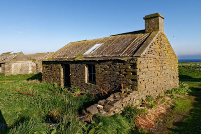 Old house on field against clear sky