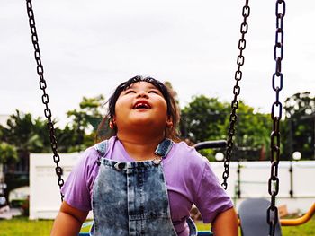 Smiling girl on swing at playground