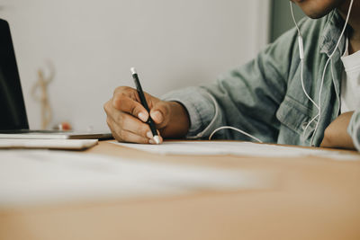 Midsection of man reading book on table