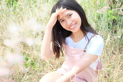 Portrait of young woman sitting on field