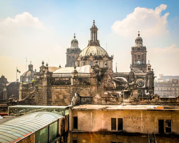 View of buildings in city against cloudy sky