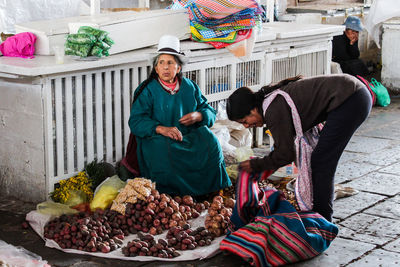 People sitting in traditional clothing outdoors