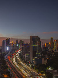 High angle view of illuminated cityscape against clear sky at night