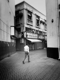 Rear view of people walking on narrow street