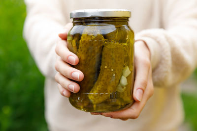 Midsection of man holding glass jar