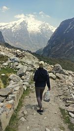 Rear view of woman walking on mountain against sky