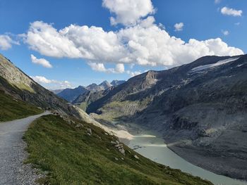 Scenic view of river by mountains against sky