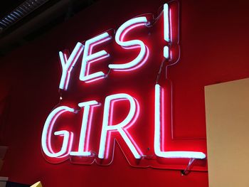 Low angle view of illuminated yes girl text on wall