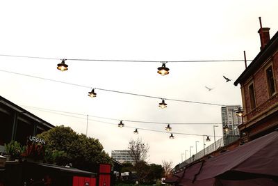 Low angle view of overhead cable cars against sky