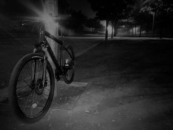 Bicycle parked on footpath at night