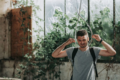 Portrait of young man standing against plants