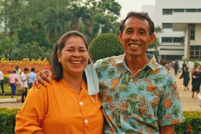 Portrait of smiling friends standing against trees