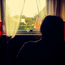 Close-up of woman looking through window