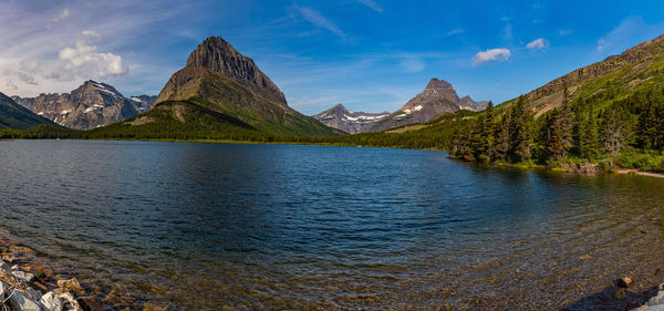 Scenic view of lake by mountains against sky