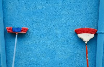 Close-up of multi colored umbrella against blue wall