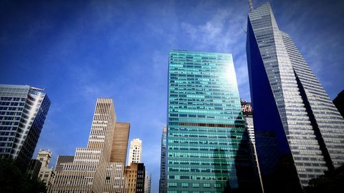 Low angle view of modern buildings against blue sky