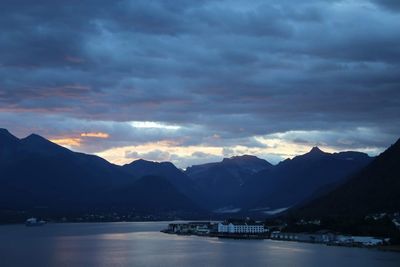 Scenic view of lake and mountains against sky during sunset