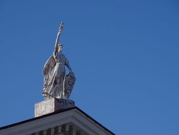 Low angle view of statue of liberty against blue sky