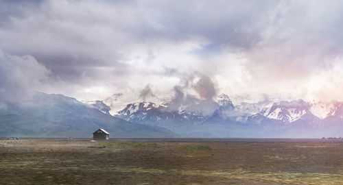 Scenic view of snowcapped mountains against cloudy sky