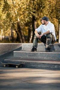 Full length of man sitting on steps in park