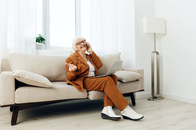 Young woman sitting on sofa at home