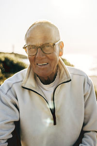 Portrait of smiling senior man wearing eyeglasses on sunset