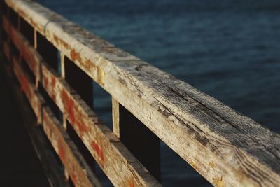 Close-up of wooden railing over lake