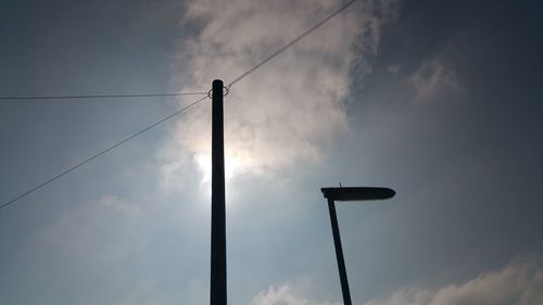 Low angle view of street light against cloudy sky