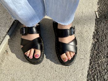 Low section of woman standing on footpath