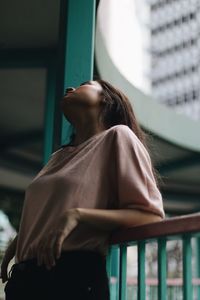 Low angle view of woman standing by railing