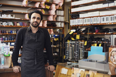 Portrait of man standing in shoe repair store